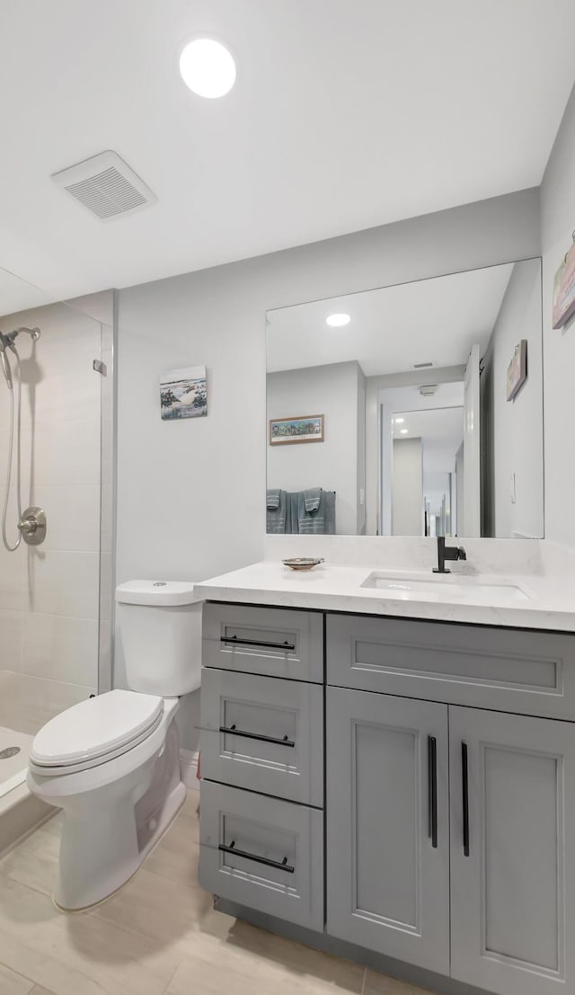 bathroom with toilet, vanity, and an enclosed shower