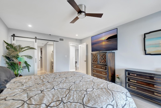 bedroom featuring ceiling fan and a barn door