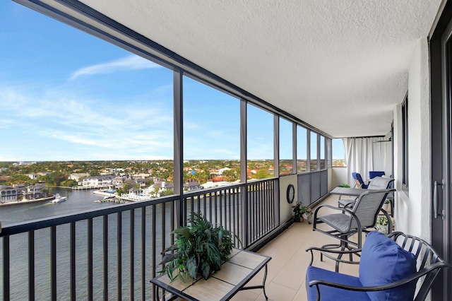 sunroom featuring a water view