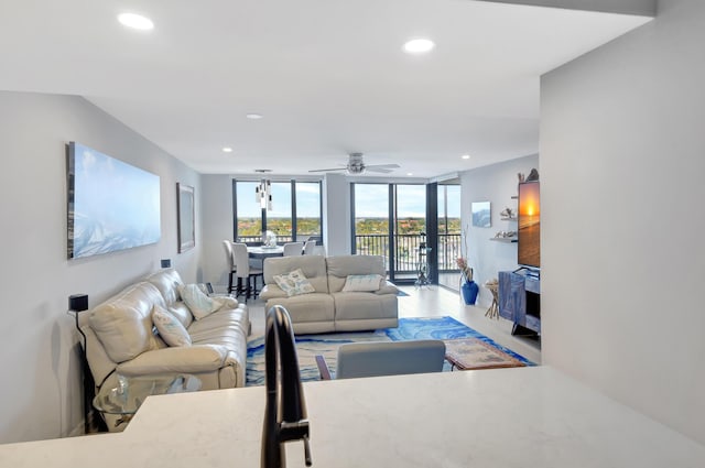 living room featuring ceiling fan, expansive windows, and french doors