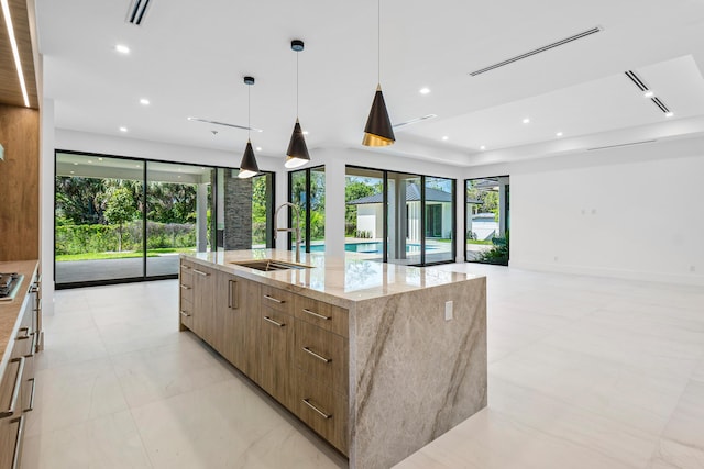 3100 Palm Dr, Delray Beach, FL 33483 - kitchen featuring a large island, visible vents, a sink, modern cabinets, and light stone countertops
