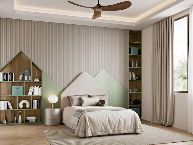 bedroom featuring hardwood / wood-style flooring, ceiling fan, and a tray ceiling