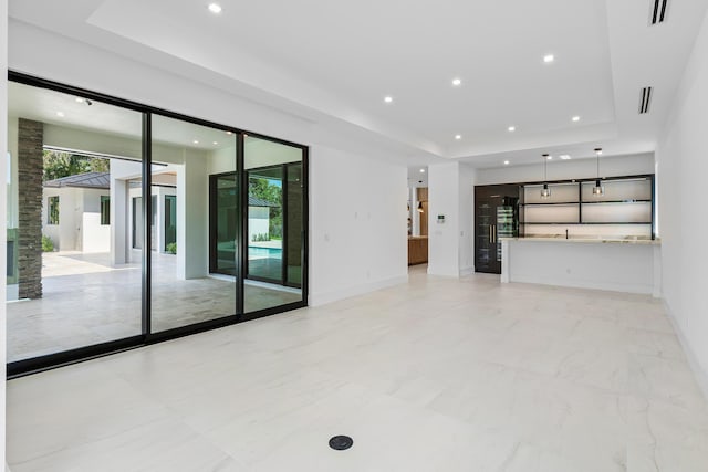 3100 Palm Dr, Delray Beach, FL 33483 - unfurnished living room featuring baseboards, a tray ceiling, visible vents, and recessed lighting