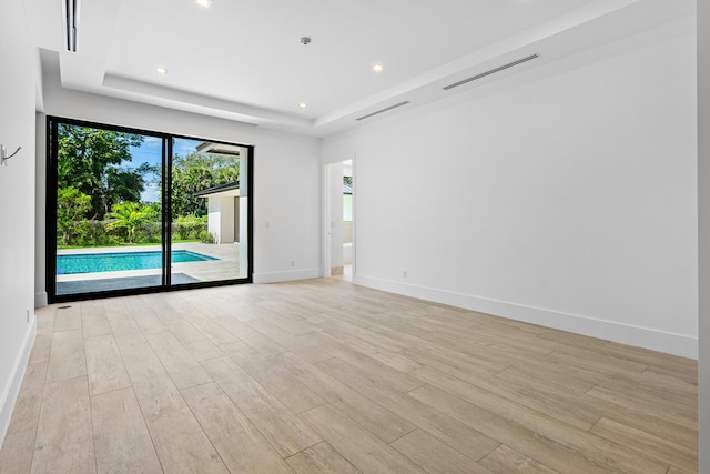 3100 Palm Dr, Delray Beach, FL 33483 - empty room with visible vents, light wood-style flooring, and a tray ceiling