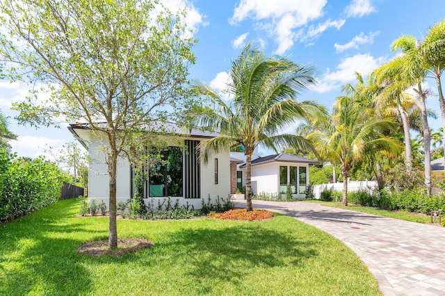 3100 Palm Dr, Delray Beach, FL 33483 - ranch-style home featuring a standing seam roof, driveway, fence, a front yard, and stucco siding