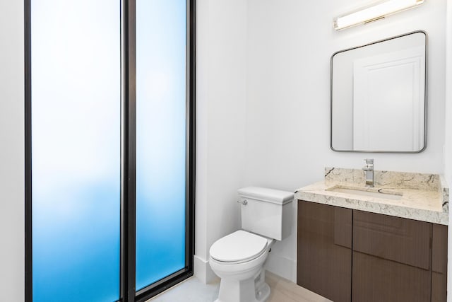 3100 Palm Dr, Delray Beach, FL 33483 - bathroom featuring toilet, vanity, and baseboards
