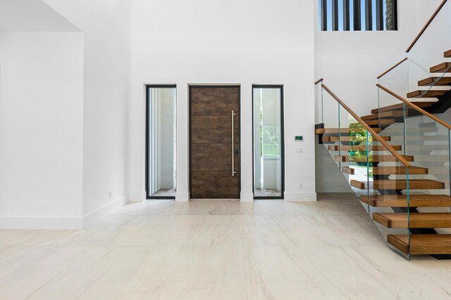 3100 Palm Dr, Delray Beach, FL 33483 - entryway with stairway, marble finish floor, baseboards, and a high ceiling