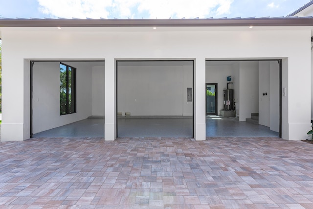 3100 Palm Dr, Delray Beach, FL 33483 - view of patio with a garage, water heater, and driveway