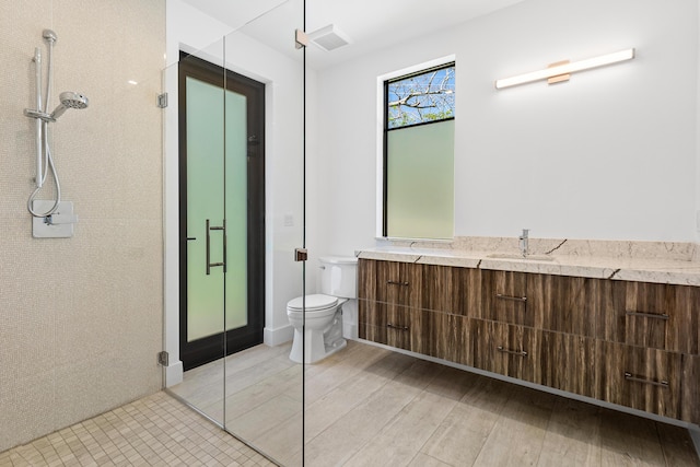 3100 Palm Dr, Delray Beach, FL 33483 - bathroom featuring wood finished floors, vanity, a shower with door, toilet, and visible vents
