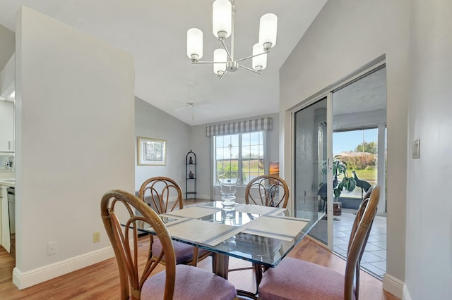 dining space with lofted ceiling, light wood-type flooring, and ceiling fan with notable chandelier