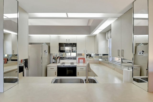 kitchen featuring refrigerator, sink, white cabinetry, range with electric stovetop, and white refrigerator