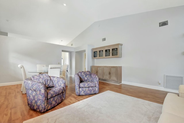 living room with light wood-type flooring and lofted ceiling