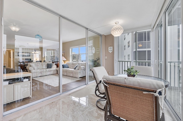 sunroom / solarium featuring a notable chandelier