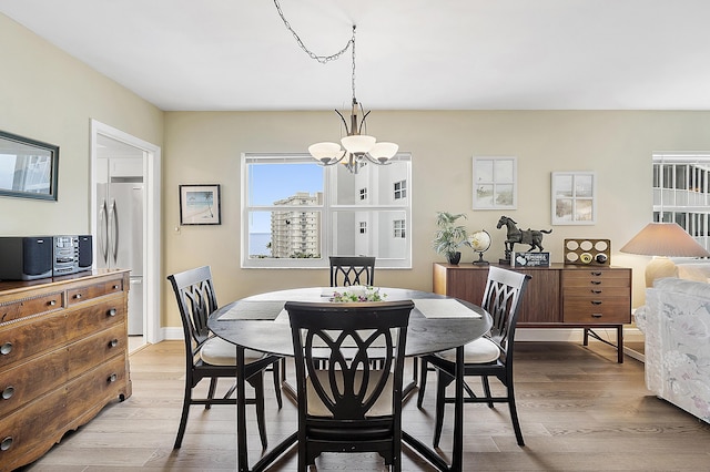 dining area with a chandelier and light hardwood / wood-style flooring