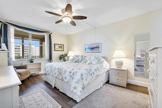 bedroom with dark hardwood / wood-style flooring, a textured ceiling, and ceiling fan