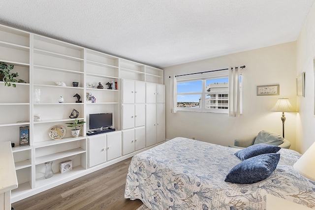 bedroom featuring wood-type flooring and a textured ceiling