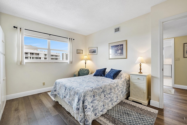 bedroom with dark hardwood / wood-style flooring and a textured ceiling