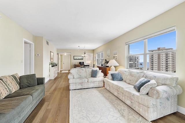 living room featuring a chandelier and light hardwood / wood-style flooring