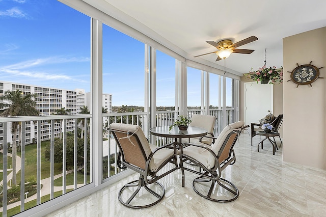 sunroom / solarium featuring ceiling fan