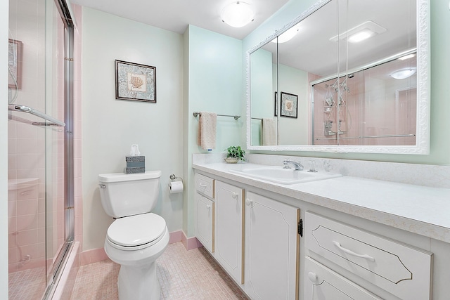 bathroom with vanity, tile patterned floors, a shower with door, and toilet