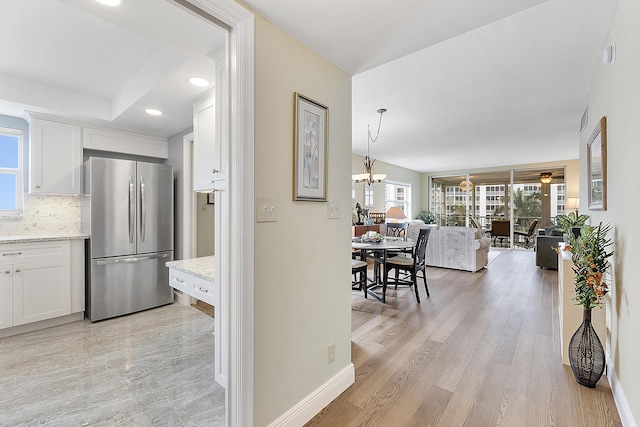 hall featuring light hardwood / wood-style flooring and a notable chandelier