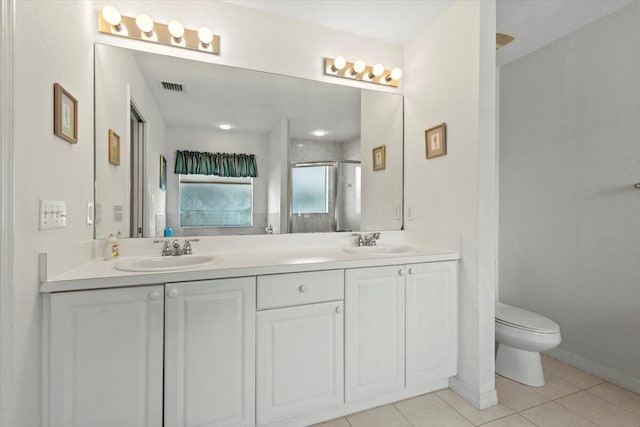 bathroom featuring toilet, tile patterned flooring, a shower with shower door, and vanity