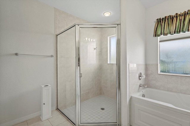 full bathroom featuring a garden tub, a stall shower, and tile patterned floors