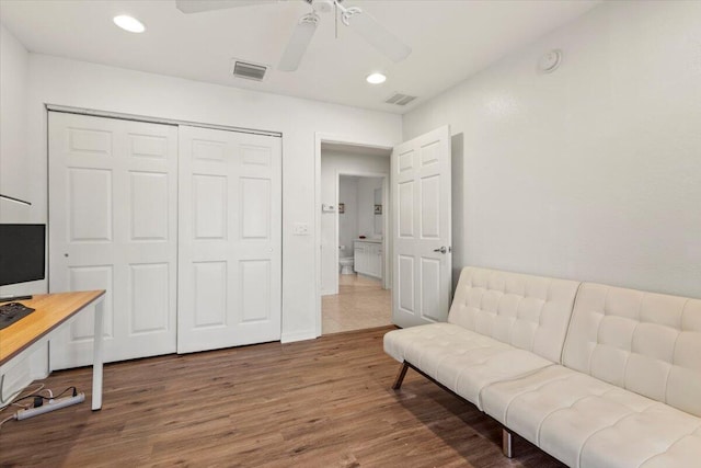 sitting room featuring wood-type flooring and ceiling fan