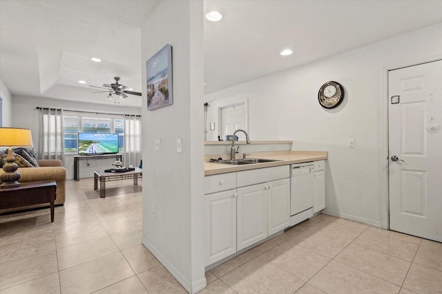 kitchen with a sink, white cabinetry, open floor plan, light countertops, and dishwasher