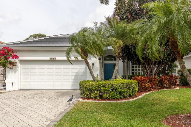 ranch-style home featuring a garage and a front yard