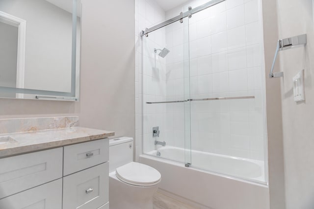 full bathroom featuring bath / shower combo with glass door, toilet, and vanity