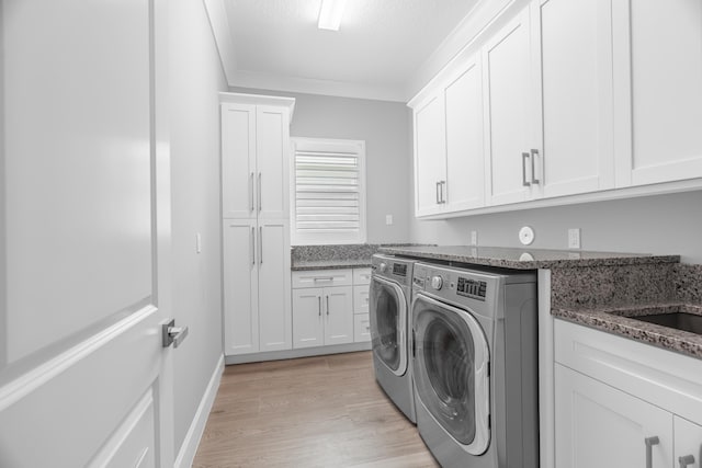 washroom featuring light wood-type flooring, cabinets, crown molding, and independent washer and dryer