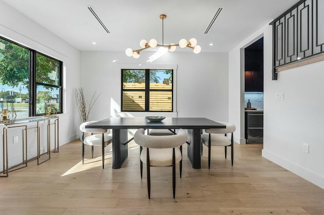 dining area featuring a notable chandelier and light hardwood / wood-style flooring