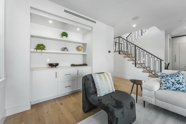 living room featuring light hardwood / wood-style floors and built in shelves