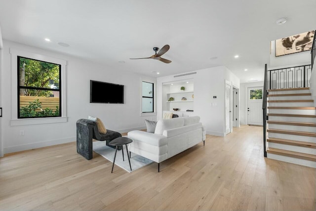 living room with ceiling fan, light hardwood / wood-style floors, and built in features