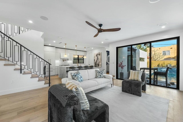 living room featuring ceiling fan and light hardwood / wood-style floors