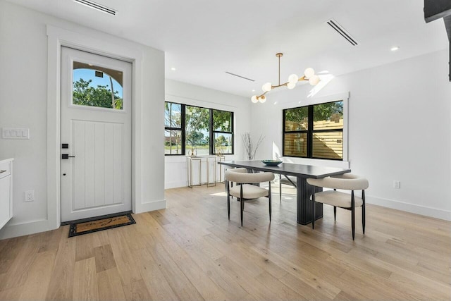 dining room featuring light wood-type flooring and a notable chandelier