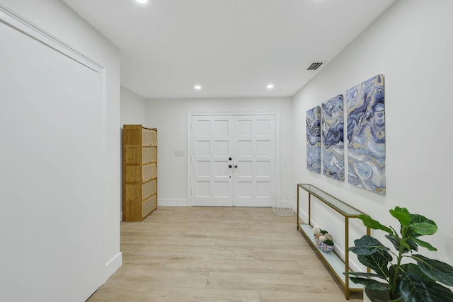 corridor with light hardwood / wood-style floors