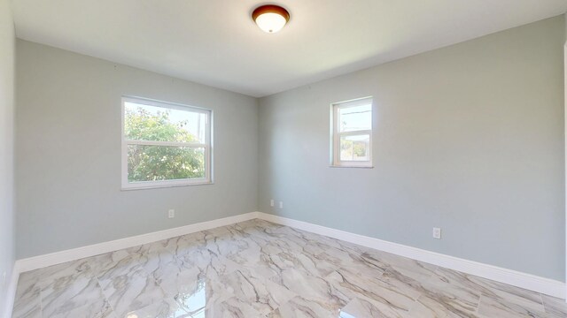 601 SE Karrigan Ter, Port Saint Lucie, FL 34983 - empty room featuring plenty of natural light and light marble finish flooring