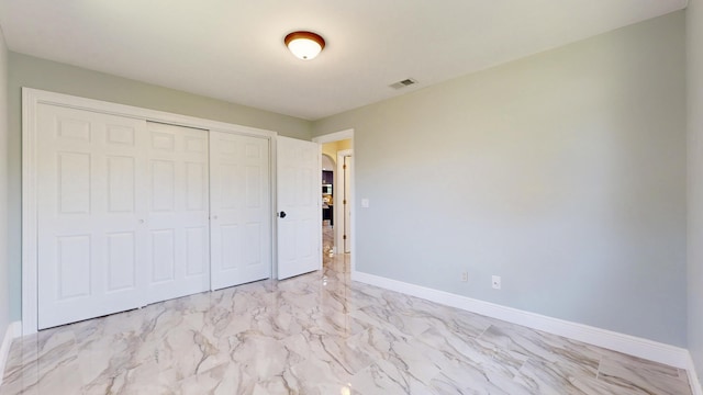601 SE Karrigan Ter, Port Saint Lucie, FL 34983 - unfurnished bedroom with light marble finish floors, arched walkways, and a closet