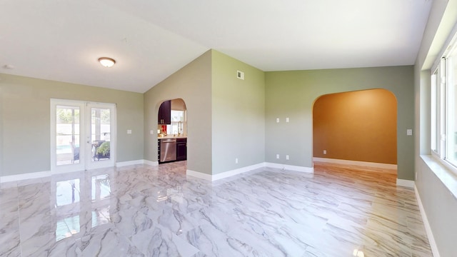 601 SE Karrigan Ter, Port Saint Lucie, FL 34983 - unfurnished room with arched walkways, light marble finish flooring, french doors, and lofted ceiling