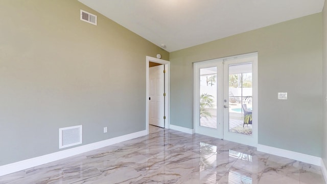 601 SE Karrigan Ter, Port Saint Lucie, FL 34983 - empty room featuring french doors, marble tiled flooring, and vaulted ceiling