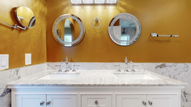 601 SE Karrigan Ter, Port Saint Lucie, FL 34983 - full bathroom with tile walls, double vanity, and a wainscoted wall