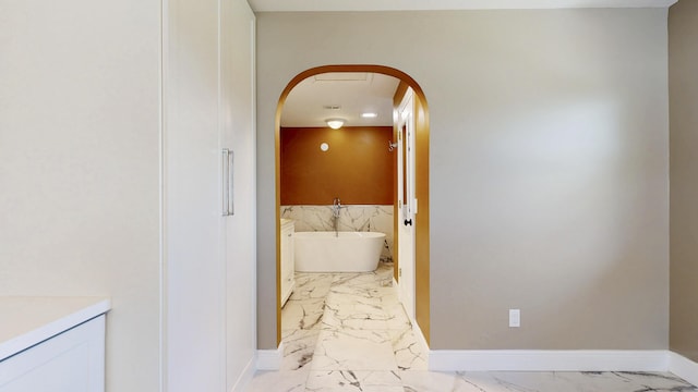 601 SE Karrigan Ter, Port Saint Lucie, FL 34983 - corridor featuring light marble finish flooring and arched walkways