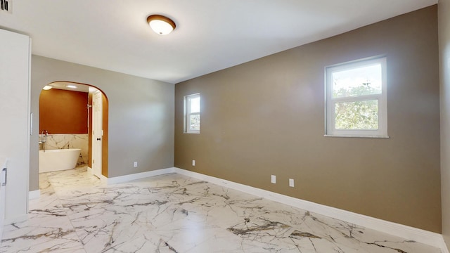 601 SE Karrigan Ter, Port Saint Lucie, FL 34983 - spare room featuring arched walkways and marble finish flooring