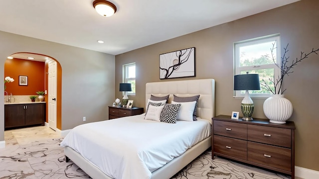 601 SE Karrigan Ter, Port Saint Lucie, FL 34983 - bedroom with light marble finish floors, arched walkways, ensuite bath, and recessed lighting