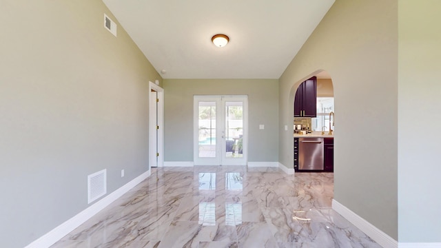 601 SE Karrigan Ter, Port Saint Lucie, FL 34983 - unfurnished dining area with french doors, arched walkways, and light marble finish floors