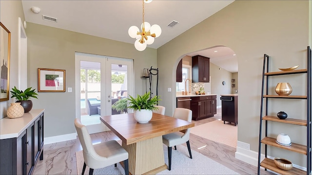 601 SE Karrigan Ter, Port Saint Lucie, FL 34983 - dining room with arched walkways, a chandelier, lofted ceiling, light marble finish floors, and french doors