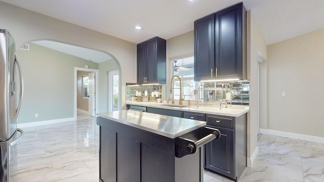 601 SE Karrigan Ter, Port Saint Lucie, FL 34983 - kitchen with arched walkways, stainless steel refrigerator with ice dispenser, light marble finish floors, light countertops, and a center island