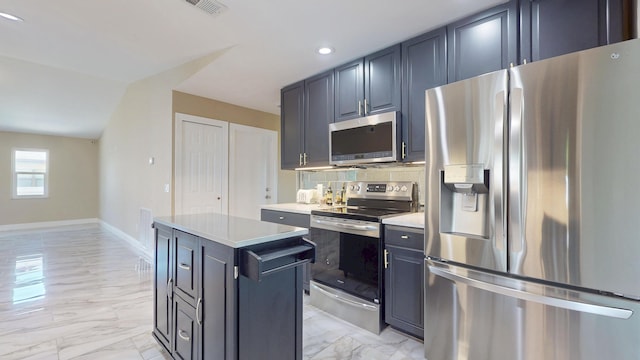 601 SE Karrigan Ter, Port Saint Lucie, FL 34983 - kitchen with stainless steel appliances, light marble finish flooring, a kitchen island, light countertops, and recessed lighting